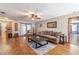 Spacious living room with a brown sofa, wooden floors, and decorative accents at 5521 Oak St, Mount Dora, FL 32757