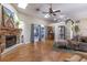Open living room featuring a stone fireplace, fan, and sliding doors to the outside at 5521 Oak St, Mount Dora, FL 32757