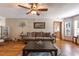 Comfortable living room with brown sofa, ceiling fan, and views of the outdoor scenery at 5521 Oak St, Mount Dora, FL 32757