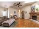 Comfortable living room featuring a stone fireplace, ceiling fan, and lots of natural light at 5521 Oak St, Mount Dora, FL 32757