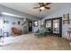 Open concept sunroom with ample seating, two ceiling fans, tile flooring and access to an outdoor patio at 5521 Oak St, Mount Dora, FL 32757