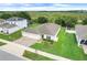 Aerial view of a well-manicured lawn and single story home with a three-car garage, surrounded by green space at 641 Black Eagle Dr, Groveland, FL 34736