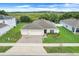 Aerial view of a charming home with three car garage, manicured lawn, and delightful landscaping at 641 Black Eagle Dr, Groveland, FL 34736