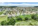 Expansive aerial view of a residential community featuring well-maintained homes and landscaping with a lake in the background at 641 Black Eagle Dr, Groveland, FL 34736