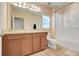 Comfortable bathroom featuring double sinks, wood cabinets, toilet and shower/tub combination at 641 Black Eagle Dr, Groveland, FL 34736