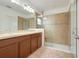 Beautiful bathroom features double sinks, wood cabinets, and a glass enclosed shower with tiled walls at 641 Black Eagle Dr, Groveland, FL 34736
