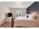 Comfortable bedroom featuring a wooden bed frame, ceiling fan, and a large window with natural light at 641 Black Eagle Dr, Groveland, FL 34736