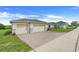 Front of a single story home with a three-car garage, brick driveway, and lush landscaping, set in a quiet neighborhood at 641 Black Eagle Dr, Groveland, FL 34736