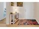 The entryway of a home is decorated with a rustic wooden console table with a lamp, art, and a colorful rug at 641 Black Eagle Dr, Groveland, FL 34736