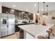 Modern kitchen featuring an island with pendant lights, stainless steel appliances, and dark cabinets at 641 Black Eagle Dr, Groveland, FL 34736