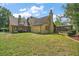 Expansive backyard with a screened pool, mature trees, and charming home exterior at 707 S Dixie Dr, Howey In The Hills, FL 34737