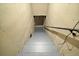 View of concrete basement stairs leading down with handrail for added safety and support at 707 S Dixie Dr, Howey In The Hills, FL 34737