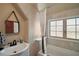 Bathroom features a combined shower and tub, a vanity, and a frosted window at 707 S Dixie Dr, Howey In The Hills, FL 34737