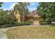 Front view of a property with manicured lawn, mature trees, and a charming exterior at 707 S Dixie Dr, Howey In The Hills, FL 34737
