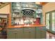 Kitchen area featuring stylish green cabinets, wooden countertops, and glass-front cabinets at 707 S Dixie Dr, Howey In The Hills, FL 34737