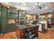 Gourmet kitchen with a center island, stainless steel appliances, and custom green cabinetry at 707 S Dixie Dr, Howey In The Hills, FL 34737
