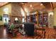 Bright living room with wood ceiling, grand stone fireplace, built-ins, and hardwood flooring at 707 S Dixie Dr, Howey In The Hills, FL 34737