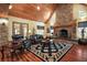 Bright living room with wood ceiling, grand stone fireplace, built-ins, hardwood flooring, and comfortable seating at 707 S Dixie Dr, Howey In The Hills, FL 34737