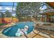 Inviting screened-in pool with a flamingo floatie, spa, and outdoor seating area at 707 S Dixie Dr, Howey In The Hills, FL 34737
