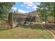 Screened pool with chairs, surrounded by grassy backyard and mature trees at 707 S Dixie Dr, Howey In The Hills, FL 34737