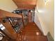 A stairway descends past wood railing, into a living area with stone accents and decorative carpet at 707 S Dixie Dr, Howey In The Hills, FL 34737