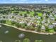Stunning aerial perspective of a lakeside community featuring beautifully landscaped homes with serene water views and green spaces at 727 Turnberry Ln, The Villages, FL 32159