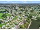Aerial shot of a beautiful lakeside community, showcasing well-maintained homes and lush green spaces with lake view at 727 Turnberry Ln, The Villages, FL 32159