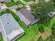 Aerial view of a cozy home with a screened lanai and lush backyard in a well-maintained neighborhood at 727 Turnberry Ln, The Villages, FL 32159