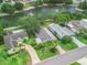 An aerial view of a well manicured home and lawn in a lakefront community at 727 Turnberry Ln, The Villages, FL 32159