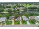 Birds eye view of a charming neighborhood with beautifully maintained homes, lush greenery, and a tranquil lake at 727 Turnberry Ln, The Villages, FL 32159