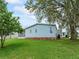 Picture of a well-maintained backyard, showcasing a charming home nestled under mature trees and healthy green grass at 727 Turnberry Ln, The Villages, FL 32159