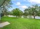Green backyard with grass leading to water view with trees and fountain at 727 Turnberry Ln, The Villages, FL 32159