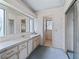 Bathroom boasts large vanity with mirror and cabinets, and wallpaper with a floral pattern at 727 Turnberry Ln, The Villages, FL 32159