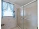 Bathroom with window and translucent glass enclosed shower with metal sliding doors at 727 Turnberry Ln, The Villages, FL 32159