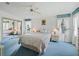 Relaxing bedroom featuring soft lighting, plush bedding, a mirrored closet, and windows with light-filtering curtains at 727 Turnberry Ln, The Villages, FL 32159