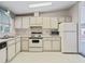 The cozy kitchen features white appliances and cabinetry, mosaic tile floors, and an inviting atmosphere at 727 Turnberry Ln, The Villages, FL 32159