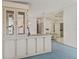 Open concept living room with glass display cabinet, white walls, and neutral carpeting at 727 Turnberry Ln, The Villages, FL 32159