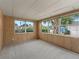 Bright sun room with wood paneled walls, neutral carpet, and exterior views at 727 Turnberry Ln, The Villages, FL 32159