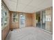 Cozy sun room features wood paneled walls, neutral carpeting, and views of the exterior at 727 Turnberry Ln, The Villages, FL 32159