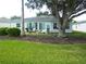 Home's sunroom and backyard patio featuring an outdoor dining set and lush lawn at 751 Old Oaks Ln, Leesburg, FL 34748