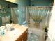 Cozy bathroom with a shower-tub combination, single vanity, and blue accent wall at 751 Old Oaks Ln, Leesburg, FL 34748
