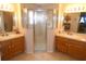 Bathroom boasting double sinks, wood cabinets, tile floors, and a tiled shower enclosure at 751 Old Oaks Ln, Leesburg, FL 34748