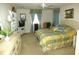 Comfortable bedroom with a ceiling fan and neutral carpet, featuring a patterned bedspread, curtains, and furniture at 751 Old Oaks Ln, Leesburg, FL 34748