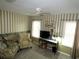 Sitting room with two sitting chairs, television, and striped accent wall with baseboard mural at 751 Old Oaks Ln, Leesburg, FL 34748