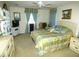 Bright bedroom featuring a ceiling fan, patterned bedspread, curtains, and matching furniture at 751 Old Oaks Ln, Leesburg, FL 34748