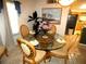Cozy dining area features a glass-top table, comfortable seating, and natural light filtering through the window at 751 Old Oaks Ln, Leesburg, FL 34748