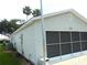 Side view of the home featuring a screened garage door and satellite dish at 751 Old Oaks Ln, Leesburg, FL 34748