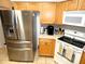 Kitchen with stainless steel appliances, tile backsplash, and wood cabinets at 751 Old Oaks Ln, Leesburg, FL 34748