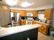 Open kitchen with stainless steel appliances, bar counter and tile flooring at 751 Old Oaks Ln, Leesburg, FL 34748