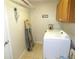 A practical laundry room with washer, dryer, overhead storage, and tile floor at 751 Old Oaks Ln, Leesburg, FL 34748